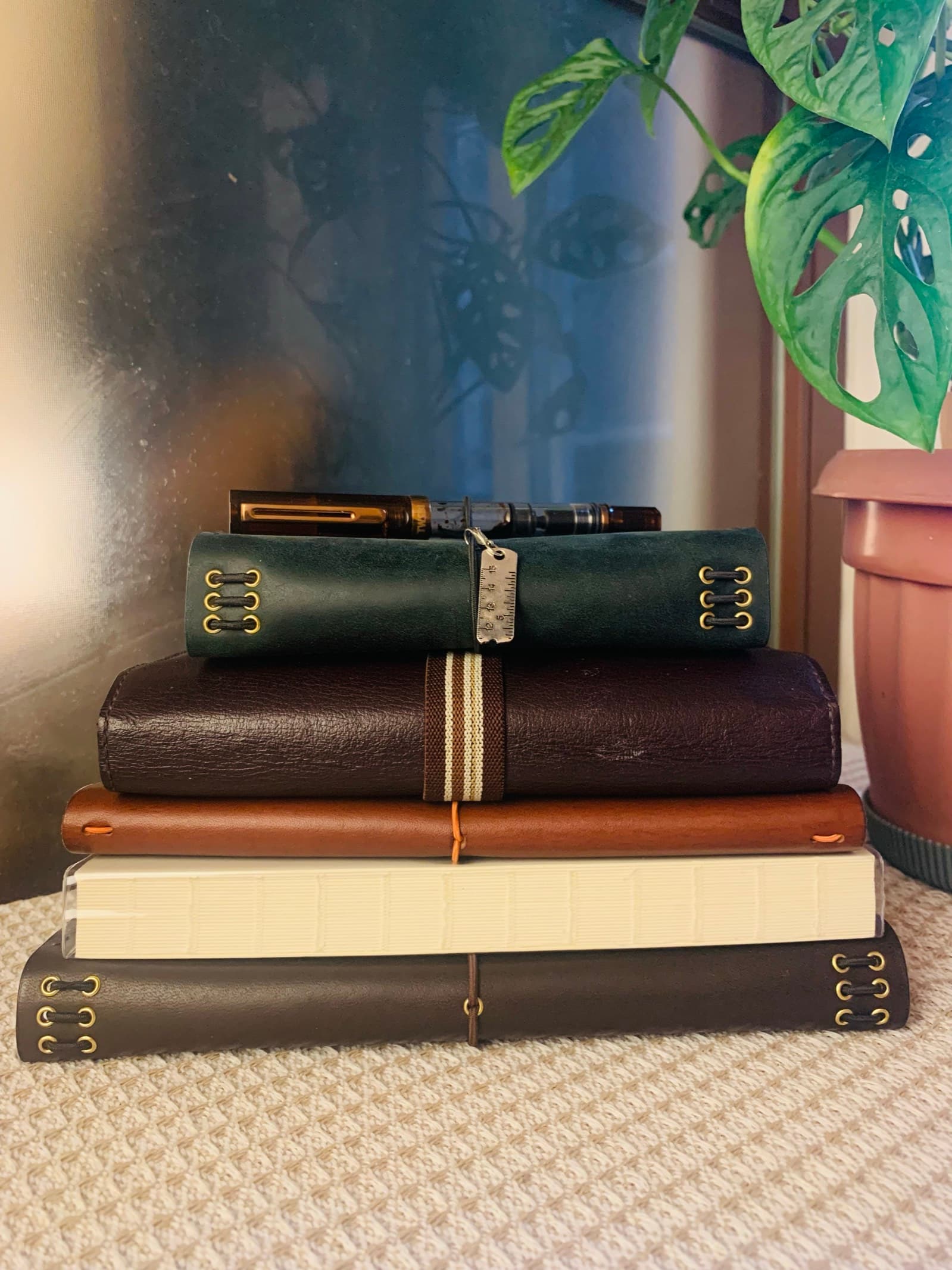 A stack of the founder's worn leather journals, a fountain pen resting on top